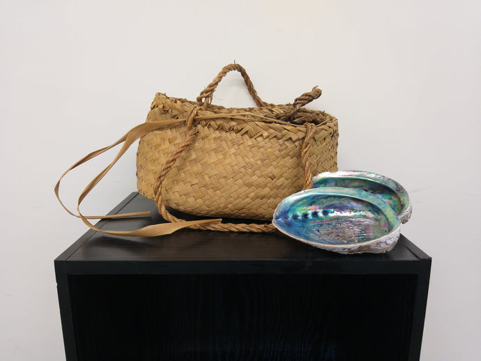 A flax kete and two pāua shells